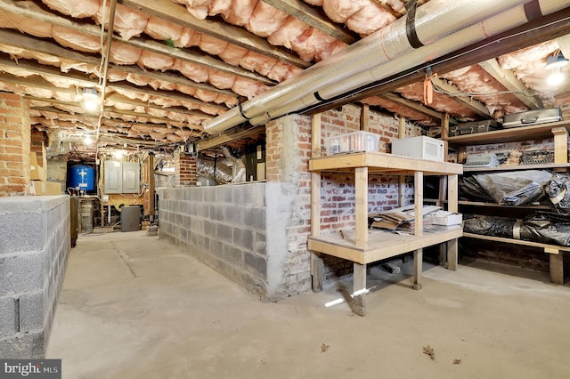 basement with electric panel and brick wall