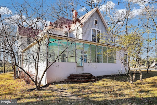 view of home's exterior with a sunroom