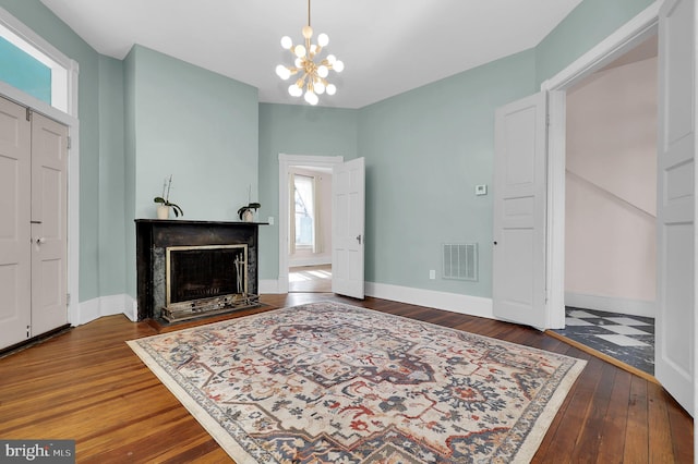 living room featuring a healthy amount of sunlight, dark wood-type flooring, and a notable chandelier