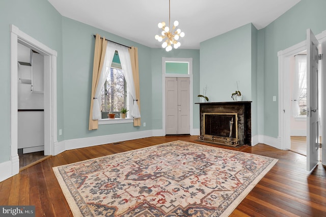 entrance foyer with dark hardwood / wood-style floors and a notable chandelier