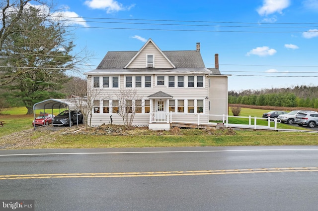 colonial house featuring a carport and a front lawn