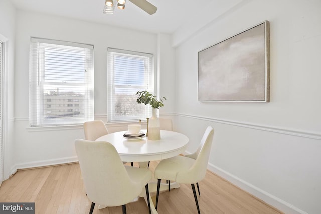 dining area with baseboards, ceiling fan, and light wood finished floors