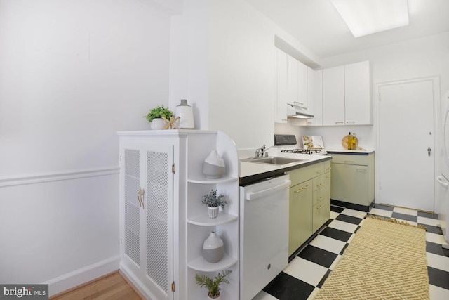 kitchen featuring light floors, a sink, range, under cabinet range hood, and dishwasher