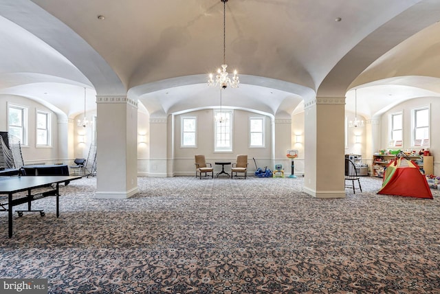 interior space with lofted ceiling, a notable chandelier, plenty of natural light, and baseboards