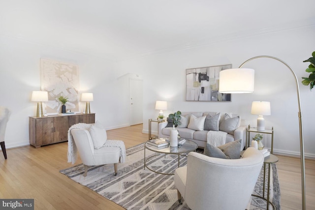 living room featuring light wood-style floors, arched walkways, and baseboards