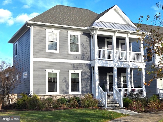 view of front of house featuring a balcony, a porch, and a front yard