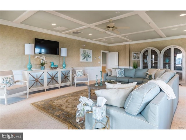 living room featuring ceiling fan, beamed ceiling, coffered ceiling, and ornamental molding