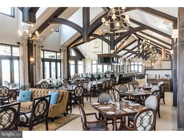 dining space featuring a healthy amount of sunlight, beam ceiling, and high vaulted ceiling