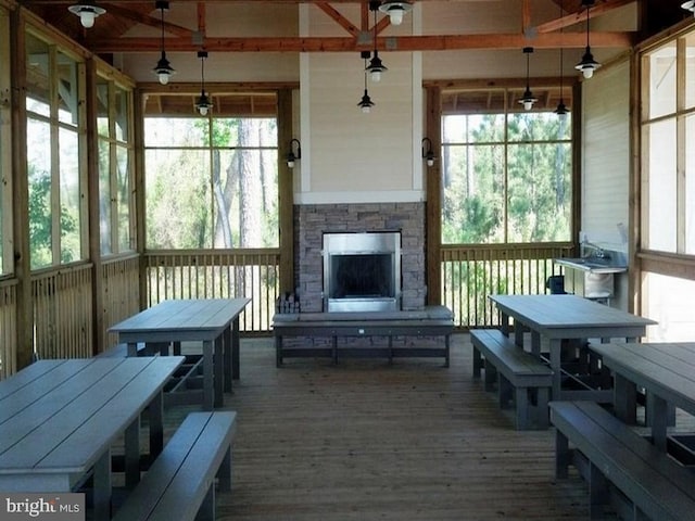 sunroom with a fireplace and beamed ceiling