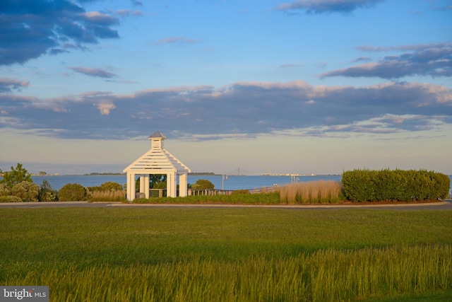 surrounding community with a gazebo, a yard, and a water view