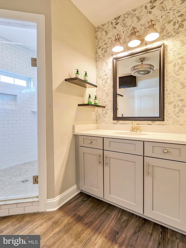 bathroom with wood-type flooring, vanity, and an enclosed shower