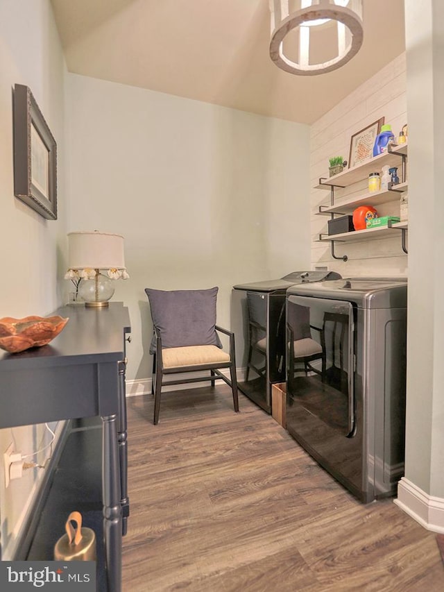 laundry room featuring a notable chandelier, wood-type flooring, and independent washer and dryer