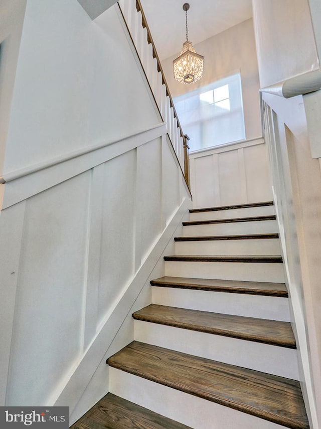 stairway featuring a chandelier and wood-type flooring