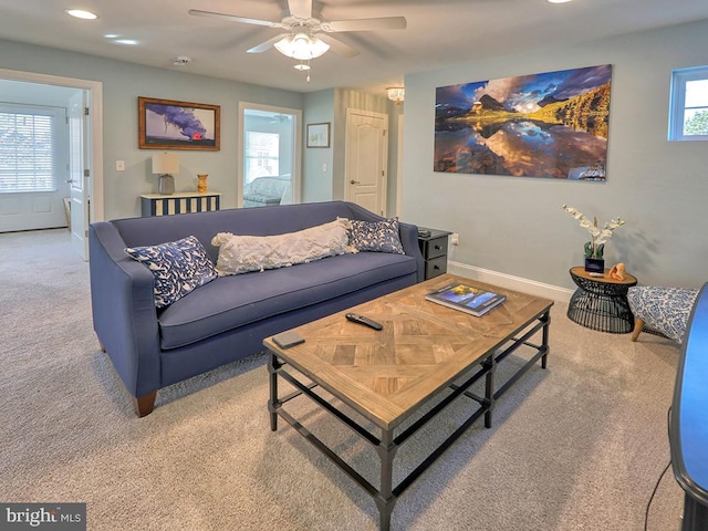 carpeted living room with ceiling fan