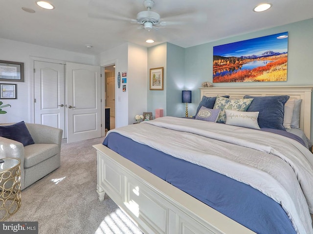 carpeted bedroom featuring ceiling fan and a closet