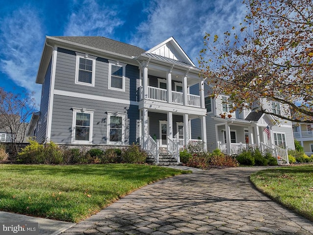 view of front of home with a porch, a balcony, and a front lawn