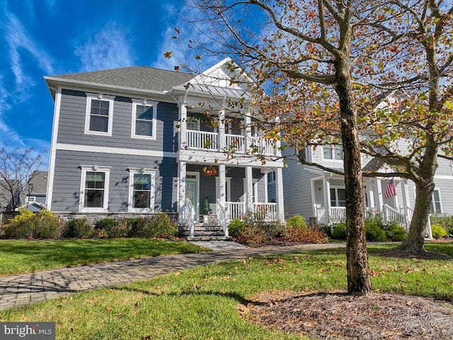 view of front of house with a balcony, a porch, and a front yard