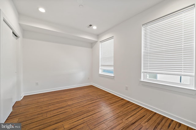 unfurnished room featuring wood-type flooring and plenty of natural light