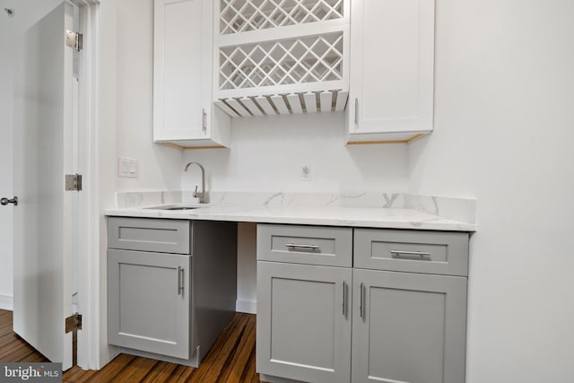 kitchen featuring gray cabinets, light stone countertops, sink, and dark hardwood / wood-style floors