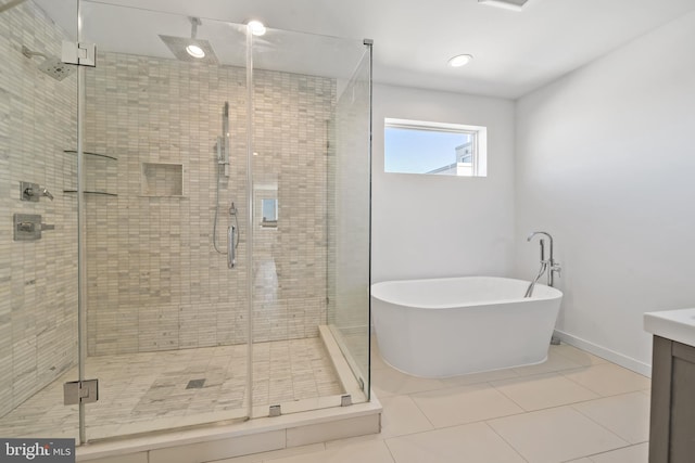 bathroom with tile patterned flooring, shower with separate bathtub, and vanity