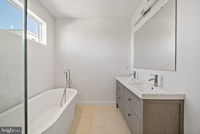 bathroom with tile patterned flooring, a bathtub, and vanity