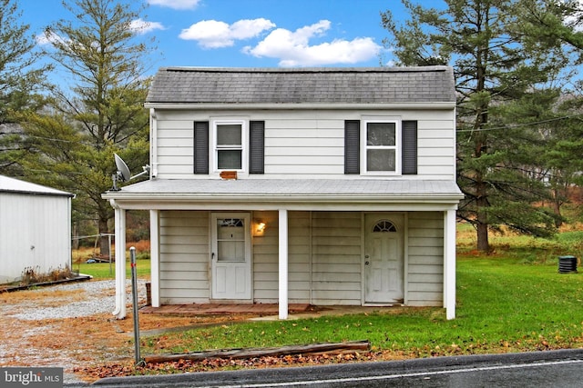 view of front of house with covered porch and a front lawn