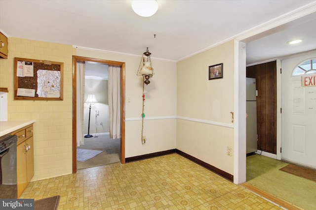 unfurnished dining area with tile walls and ornamental molding