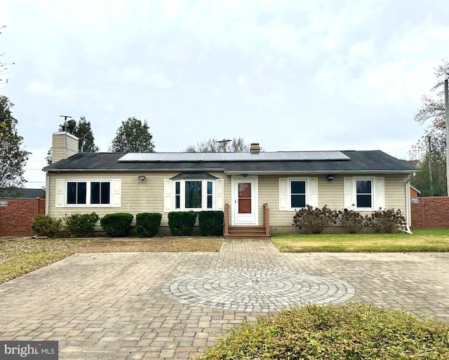 ranch-style house featuring solar panels