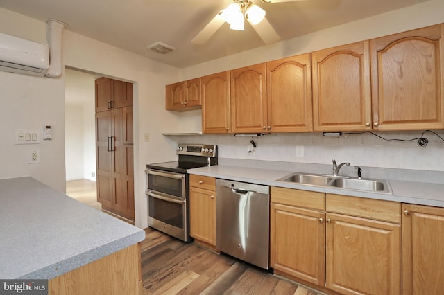 kitchen featuring backsplash, sink, wood-type flooring, stainless steel appliances, and a wall unit AC