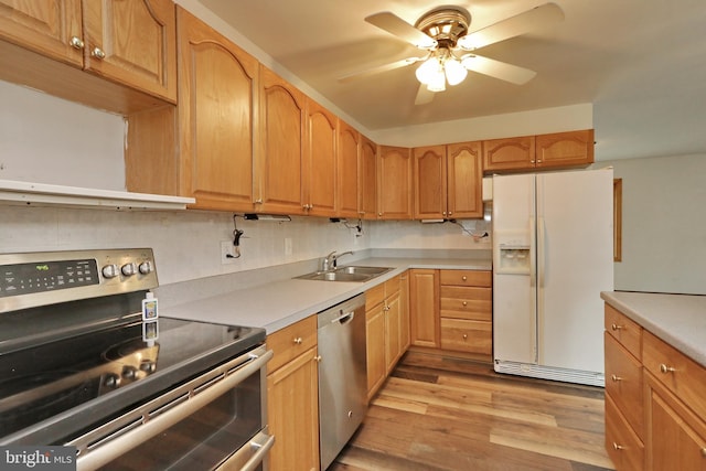 kitchen with ceiling fan, sink, tasteful backsplash, appliances with stainless steel finishes, and light wood-type flooring