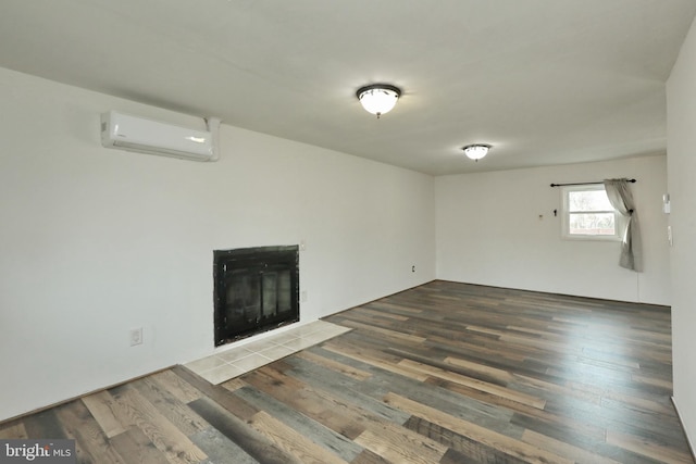 unfurnished living room featuring a wall mounted AC and dark wood-type flooring