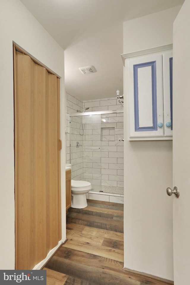 bathroom with walk in shower, vanity, wood-type flooring, and toilet