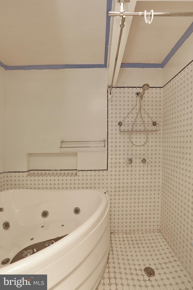 bathroom featuring tile patterned flooring, tile walls, and independent shower and bath