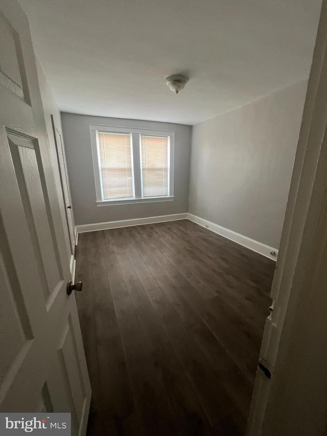 unfurnished room featuring dark hardwood / wood-style floors