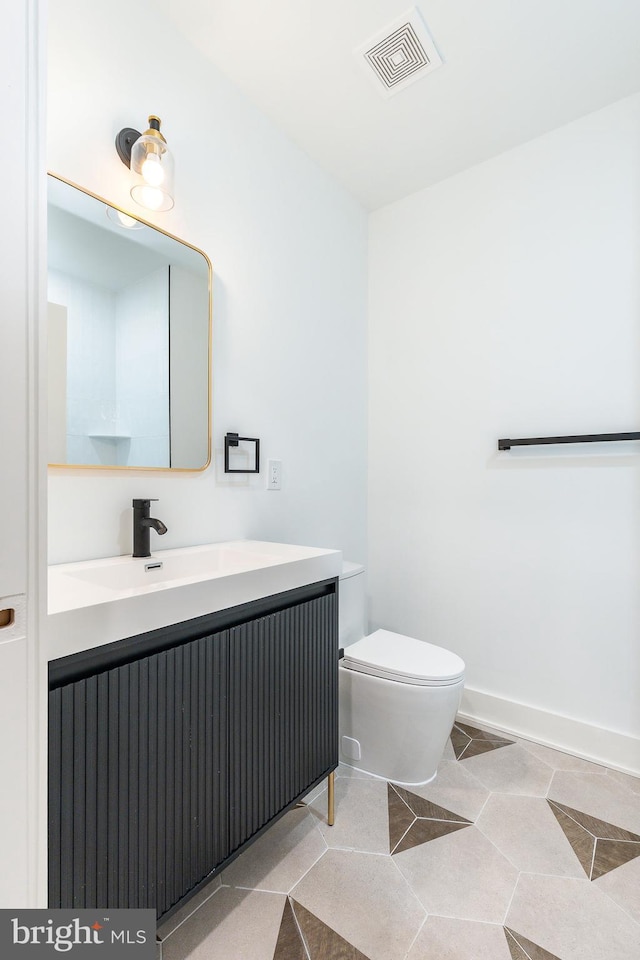 bathroom featuring tile patterned flooring, vanity, and toilet