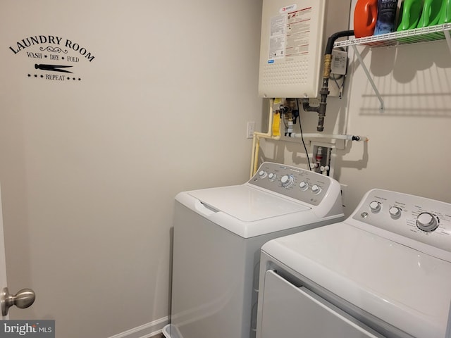 washroom featuring tankless water heater and washer and dryer