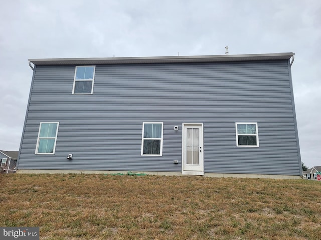 rear view of property featuring a yard