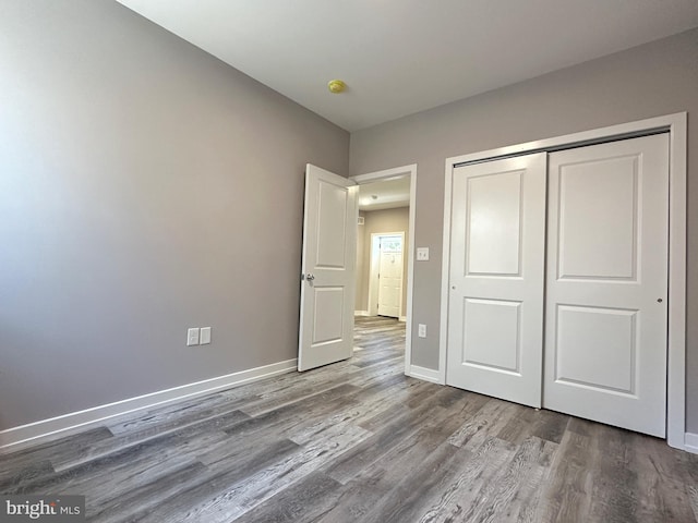 unfurnished bedroom featuring hardwood / wood-style floors and a closet