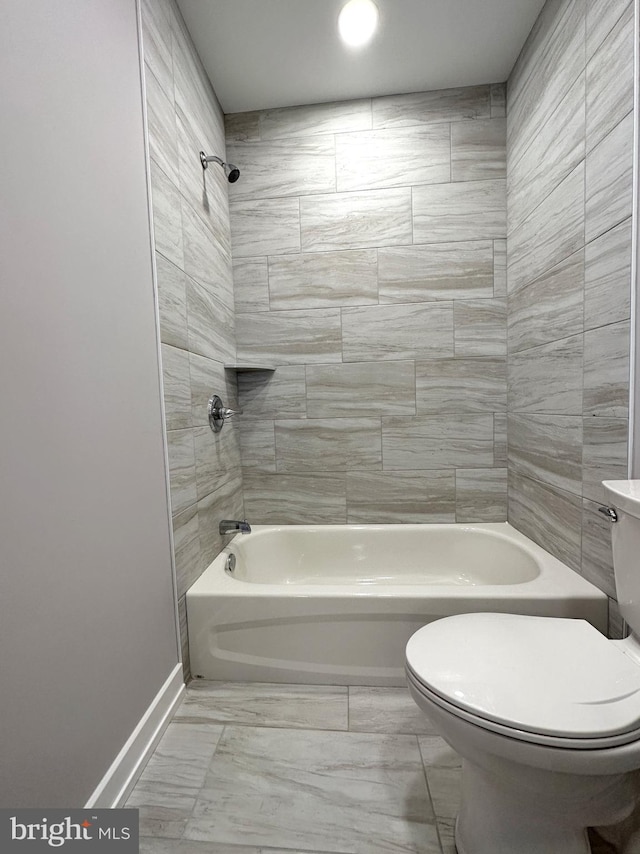 bathroom with tiled shower / bath and toilet