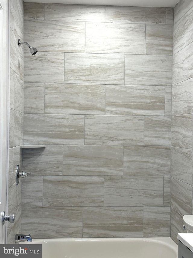 bathroom with tiled shower / bath combo and toilet