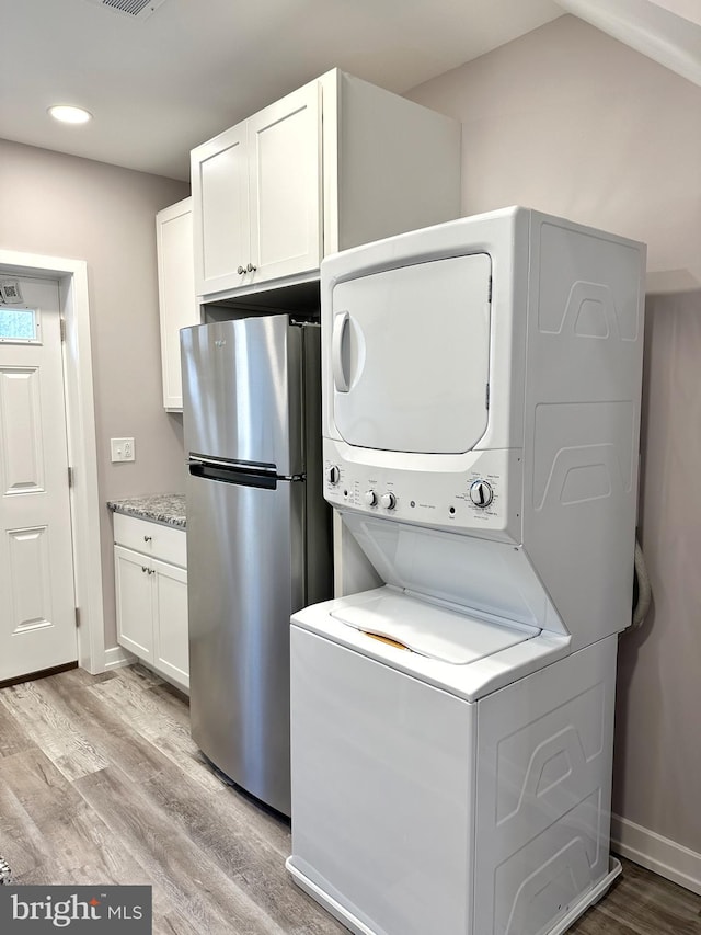 washroom featuring light wood-type flooring and stacked washer and dryer