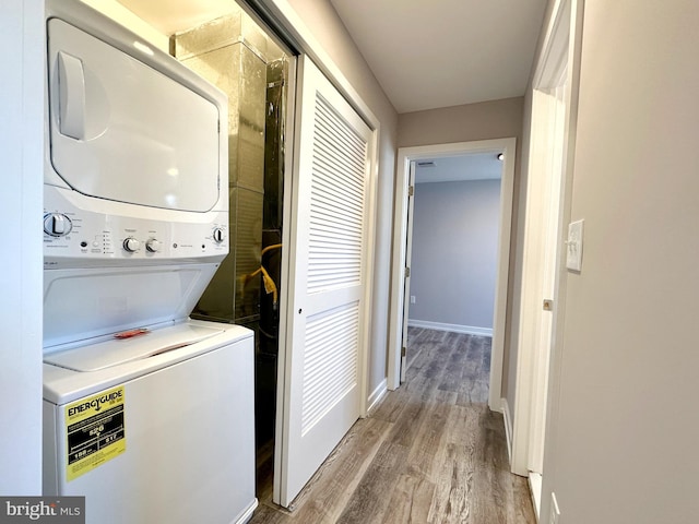 washroom featuring light hardwood / wood-style floors and stacked washing maching and dryer