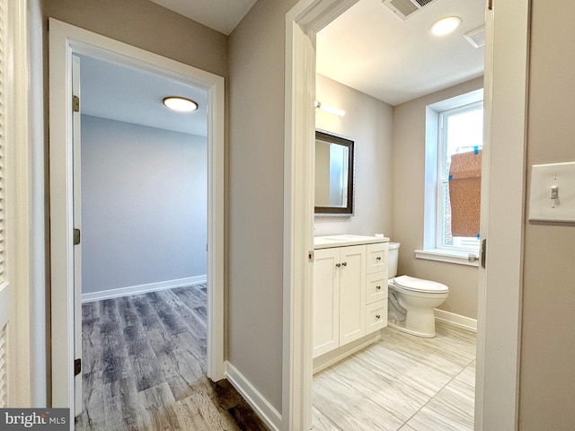 bathroom with hardwood / wood-style flooring, vanity, and toilet