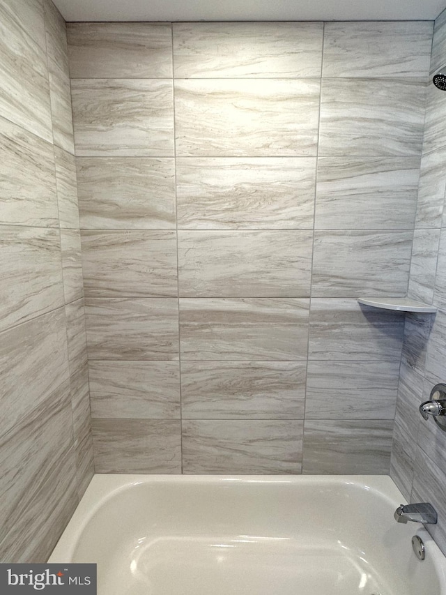 bathroom featuring tiled shower / bath