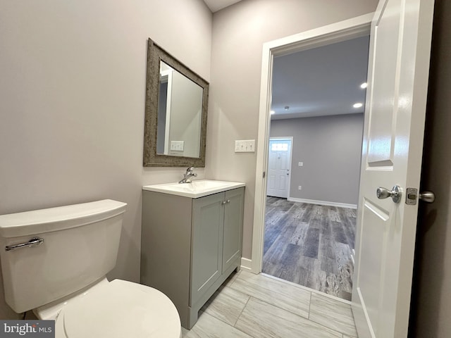 bathroom featuring hardwood / wood-style floors, vanity, and toilet