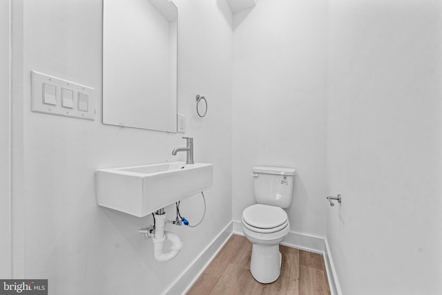 bathroom featuring wood-type flooring and toilet