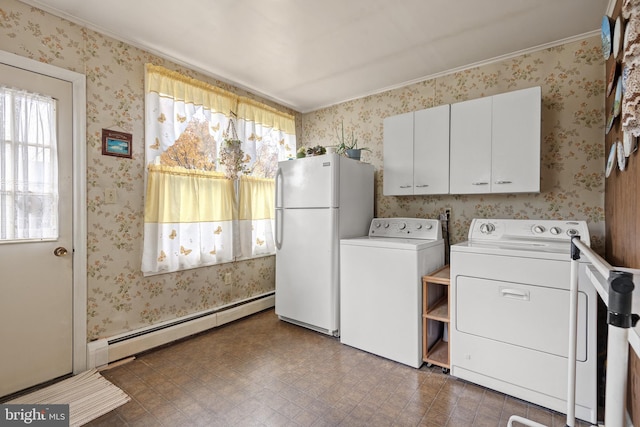 washroom with washing machine and dryer and a baseboard heating unit