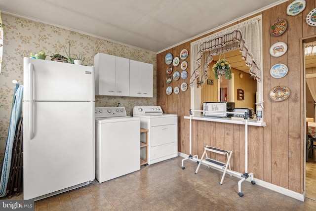 washroom with separate washer and dryer, ornamental molding, and wooden walls