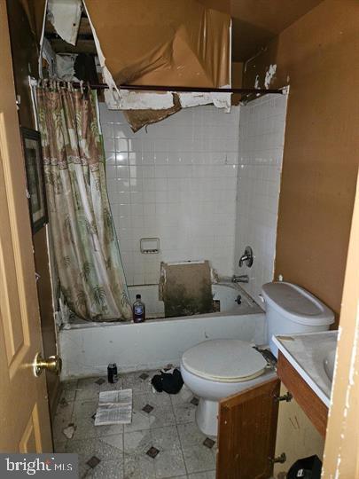 full bathroom featuring toilet, vanity, and shower / tub combo with curtain