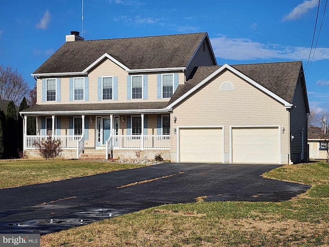 colonial-style house with a front lawn, covered porch, and a garage